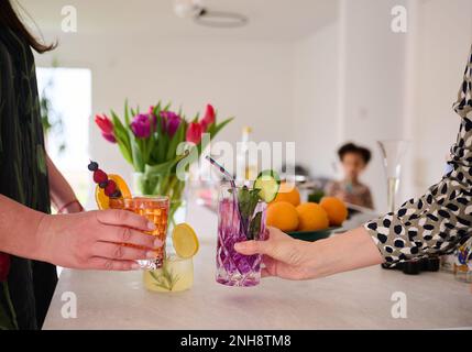 PRODUCTION - 21 février 2023, Berlin: Deux femmes toasts avec des cocktails sans alcool ( Aperol Spritz et Gin Tonic ) tandis qu'un enfant se tient en arrière-plan. L'alcool fait partie de la culture allemande. Mais de nombreux représentants de la génération Z, nés après 1997, choisissent de ne pas boire. (À dpa : « génération Z boissons différemment : la consommation d'alcool s'assèche-t-elle ? ») Photo: Annette Riedl/dpa Banque D'Images