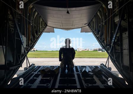 Le maître de charge de l'escadron de transport aérien 36th, Airman Carson Christian, observe une rampe de chargement arrière C-130J Super Hercules ouverte. Il aide les pilotes à faire reculer l'avion dans un emplacement de stationnement à la base aérienne de Yokota, au Japon, en 27 juillet 2022. Le C-130J Super Hercules exécute principalement la partie tactique de la mission de transport aérien. Le C-130J est capable de fonctionner à partir de bandes de terre rugueuses et constitue le principal moyen de transport des troupes et de l'équipement aéroglisseur dans les zones hostiles. Banque D'Images