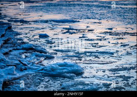 Fragments de glace couverts de neige sur l'eau gelée de la rivière. Fond naturel bleu foncé. Banque D'Images