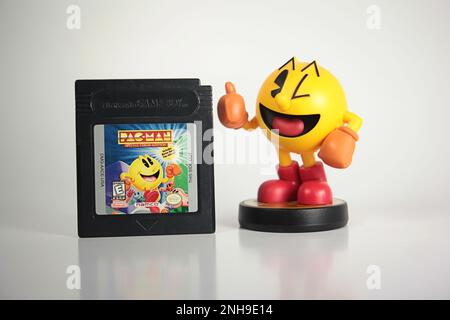 New York, NY - 10 octobre 2021 : articles de jeu vidéo Namco PAC-man. Cartouche classique Nintendo Gameboy avec figurine Amibo Switch Banque D'Images