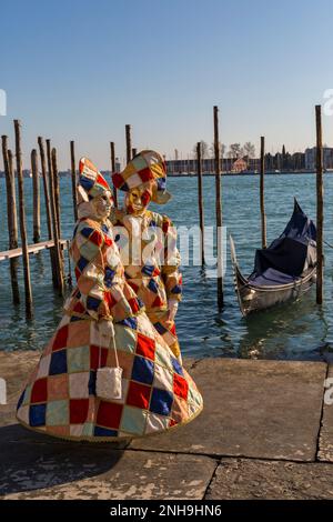 Les amateurs de carnaval vêtus de magnifiques costumes d'arlequin et de masques lors du carnaval de Venise 2023 à la place Saint-Marc, Venise, Italie en février Banque D'Images