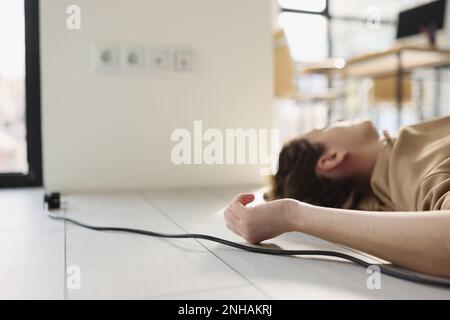 Une femme se trouve sur le sol à côté d'elle un fil, un gros plan Banque D'Images