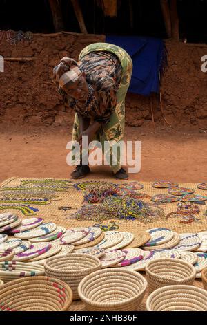 Caratu, Tanzanie - 16 octobre 2022: Un vendeur local a plié sur sa marchandise dans la banlieue de Caratu, Tanzanie. Banque D'Images