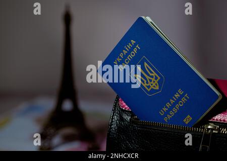 Passeport de l'Ukraine dans la poche du sac et la silhouette de la Tour Eiffel en arrière-plan Banque D'Images