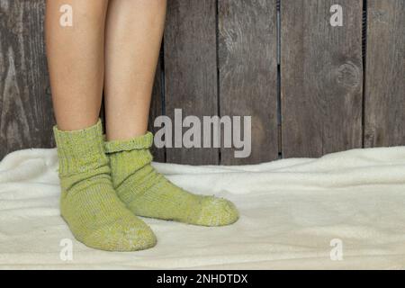 des jambes de femmes en chaussettes vertes sur un tapis blanc à la maison dans une chambre Banque D'Images