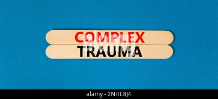 Symbole de traumatisme complexe. Concept mots trauma complexe sur bâtons en bois. Magnifique tableau bleu fond bleu. Psychologie des affaires concept de traumatisme complexe Banque D'Images