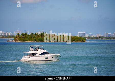 Miami, FL, Etats-Unis - 19 février 2023: Les gens font du bateau à Miami avec un yacht de luxe. Îles tropicales vertes en arrière-plan Biscayne Bay Banque D'Images