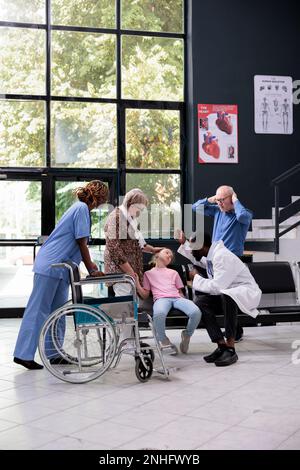 Les grands-parents ont peur après avoir épuisé leur petite-fille tombant sur une chaise dans la salle d'attente de l'hôpital pendant leur rendez-vous. Médecin consultant inconscient petit enfant avant de mettre l'expertise médicale Banque D'Images