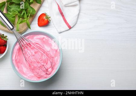 Crème fraise avec fouet ballon sur table en bois blanc, plat. Espace pour le texte Banque D'Images