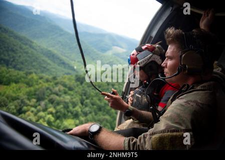 Un Airman de l’escadron tactique spéciale 123rd de la Garde nationale aérienne du Kentucky cherche des victimes d’inondations à partir d’un hélicoptère dans l’est du Kentucky sur 30 juillet 2022. En réponse à des inondations dévastatrices, l'unité a coordonné 29 missions de secours à voilure tournante, a secouru 19 personnes et deux chiens et a récupéré quatre corps. Leurs efforts de commandement et de contrôle ont également facilité l'assistance ou le rétablissement de 40 personnes. Banque D'Images