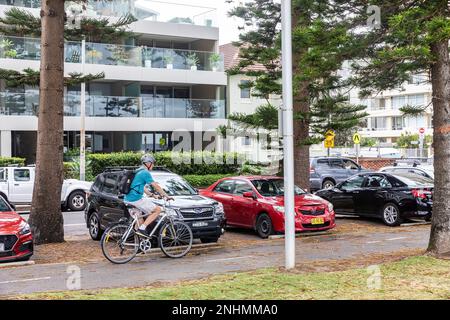 Un homme âgé, portant un casque de vélo, fait le tour de son vélo le long d'un chemin partagé à Manly Beach, en Nouvelle-Galles du Sud, en Australie Banque D'Images