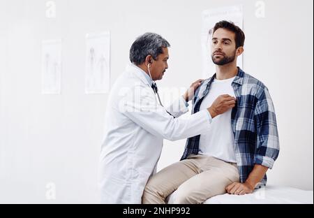 Ce qui semble être la question, monsieur. un homme mature médecin et patient ayant une discussion dans le bureau des médecins pendant un contrôle. Banque D'Images