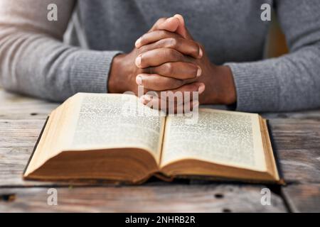 Lire le bon livre. Photo en grand angle d'un homme méconnaissable lisant sa bible tout en étant assis à l'extérieur. Banque D'Images