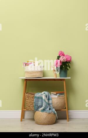 Table de console avec belle fleur de hortensia près du mur vert clair dans le couloir. Design intérieur Banque D'Images