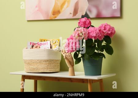 Table de console avec belle fleur de hortensia près du mur vert clair dans le couloir. Design intérieur Banque D'Images