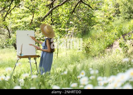 Petite fille peint sur un chevalet dans la campagne pittoresque Banque D'Images