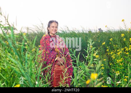 Portrait d'une femme pendjabi haute heureuse portant une tenue traditionnelle colorée debout sur le terrain de l'agriculture. Banque D'Images