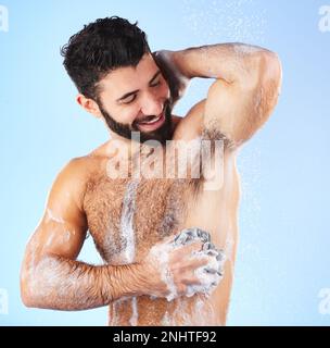 Douche, nettoyage et homme avec éponge, savon et eau dans le studio pour le bien-être, l'hygiène et le toilettage. Soins de la peau, santé et heureux homme avec de la mousse Banque D'Images