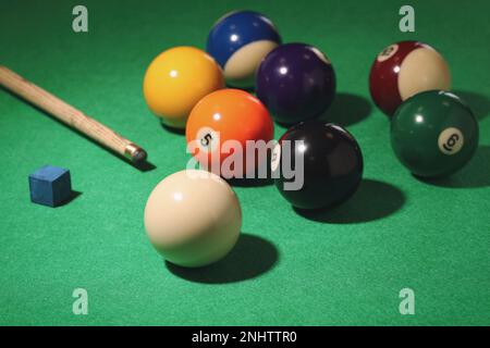 De nombreuses boules de billard colorées, des repères et de la craie sur la table verte Banque D'Images