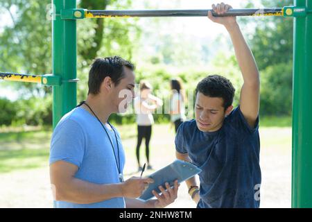 entraînement de suspension dans le parc avec entraîneur personnel de fitness Banque D'Images