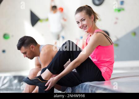 femme active et heureuse mettant des chaussures au centre d'escalade Banque D'Images