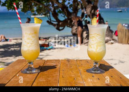 Deux cocktails d'alcool frais sur la plage. Pina colada froide sur fond marin. Deux cocktails d'ananas frais avec de la paille et de la glace. Banque D'Images