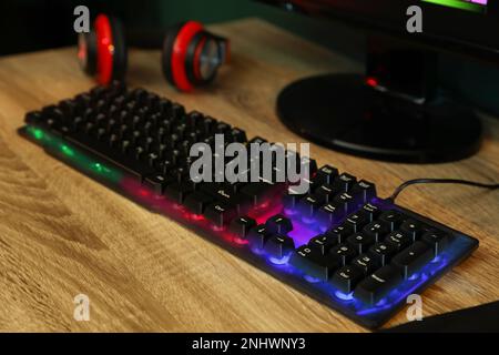 Clavier RVB moderne et ordinateur sur table en bois à l'intérieur Banque D'Images