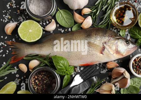 Perch frais et ingrédients crus sur table en ardoise noire, plat. Poissons de rivière Banque D'Images