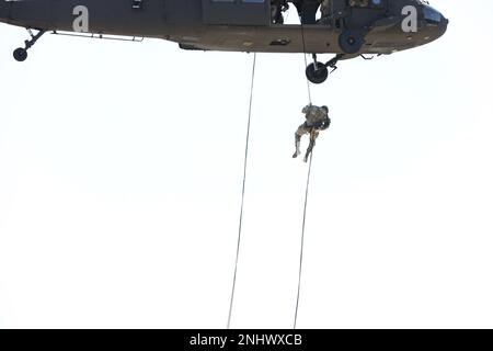 Un soldat avec la Compagnie du quartier général et du quartier général, 1st bataillon, 110th Régiment d'infanterie, 28th Division d'infanterie, sort d'un FAUCON noir UH-60 de la Brigade de l'aviation de combat expéditionnaire 28th lors d'une mission d'entraînement de rappel à fort Indiantown Gap, Pennsylvanie, on 3 août 2022. Cette formation est destinée à assurer la maîtrise des tâches et des capacités essentielles de repérage et à maintenir un niveau élevé de préparation. Banque D'Images