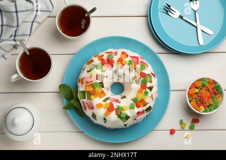 Délicieux gâteau en gelée de verre brisé sur une table en bois blanc, plat Banque D'Images