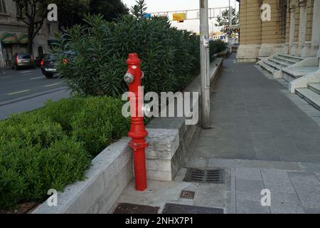 Borne d'eau rouge. Équipement de lutte contre les incendies et source d'eau placés dans la rue, sentier près de la route principale avec des voitures. Banque D'Images