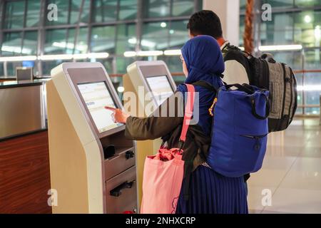 Deux vols d'enregistrement à l'aide d'un smartphone à un comptoir d'enregistrement automatique à l'aéroport Banque D'Images