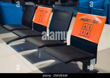 Sièges prioritaires à l'aéroport. Sièges prioritaires pour les personnes handicapées, les femmes enceintes, les mères allaitantes, les mères avec bébés ou les personnes âgées Banque D'Images