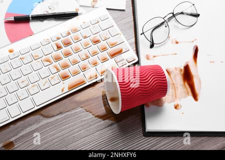 Tasse de café renversé sur le clavier d'ordinateur sur le bureau en bois, au-dessus de la vue Banque D'Images