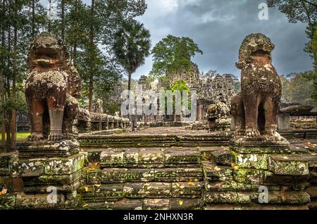 Des lions géants sur une plate-forme en pierre gardent une entrée aux ruines du célèbre temple Bayon, dans Angkor Thom et près d'Angkor Wat au Cambodge. Banque D'Images