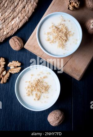 Crème maison aux noix, dessert turc muhallebi sur fond de bois. Banque D'Images