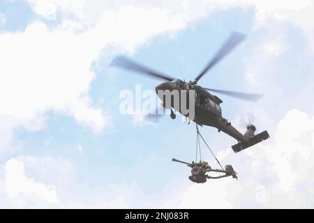 Une Armée américaine UH-60M Black Hawk affectée au 2nd Bataillon, 158th Aviation Regiment, 16th combat Aviation Brigade, porte un Howitzer M119A3 lors de l'instruction de chargement de harnais menée par des soldats américains affectés au 3rd Bataillon, 7th Field Artillery Regiment, 25th Infantry Division Artillery, 25th Infantry Division, Et des soldats du bataillon d'artillerie de campagne de 15th unités, Tentara Nasional Indonesia, pendant le Super Garuda Shield 2022 le 4 août 2022 à la zone d'entraînement de Baturaja, Indonésie. Le Super Garuda Shield 2022, qui fait partie de l'opération Pathways et d'un exercice militaire bilatéral annuel de longue date Banque D'Images