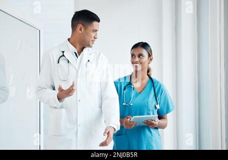 Médecin, infirmière et professionnels marchant, parlant et planifiant la chirurgie de soins de santé dans un hôpital en tant qu'experts médicaux. Médecine, comprimé et Banque D'Images