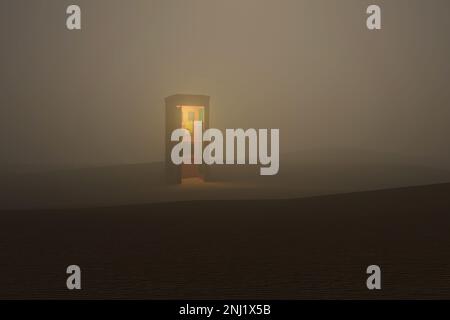 cabine téléphonique éclairée isolée dans le désert brumeux Banque D'Images