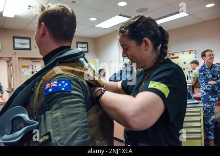 Lilah Paige, aviatrice de premier plan de la Royal Australian Air Force, du 1 Squadron, aide un pilote à corriger son gilet de survie avant un vol au cours DU DRAPEAU ROUGE Alaska 22-3 à la base aérienne d'Eielson, en Alaska, le 4 août 2022. RF-A est une plate-forme idéale pour l'engagement international, et l'exercice a une longue histoire d'inclure des alliés et des partenaires, permettant finalement à tous les participants d'échanger des tactiques, des techniques et des procédures tout en améliorant l'interopérabilité. Banque D'Images