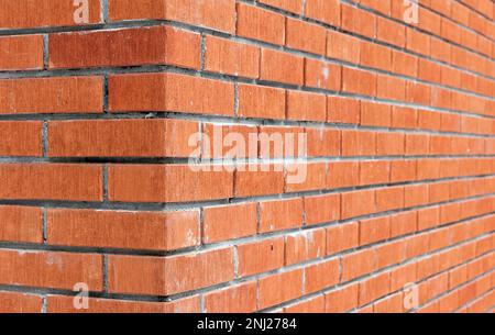 Coin du mur de briques rouges. Photo d'arrière-plan abstraite avec mise au point douce sélective Banque D'Images