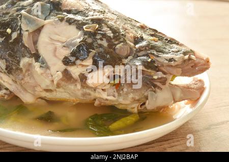 Tête de poisson-chat asiatique bouilli avec sauce au piment et au citron soupe tom yum de céleri sur l'assiette Banque D'Images