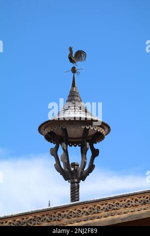 clocher traditionnel en bois sculpté de tirolean sur le toit d'une ferme avec ciel bleu en arrière-plan Banque D'Images