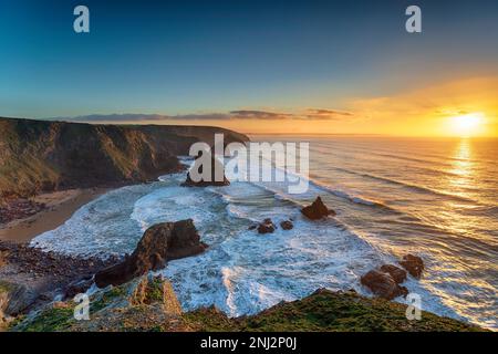 Magnifique coucher de soleil sur les piles de la mer sur la plage à Bedrithan Steps près de Newquay dans Cornwall Banque D'Images