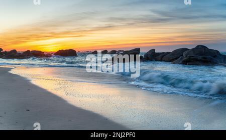 Coucher de soleil sur la plage de Meneham sur la côte sauvage de Bretagne en France Banque D'Images
