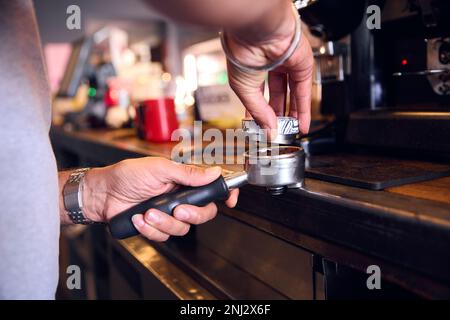 Gros plan du Barista au café en utilisant la machine pour préparer le café Banque D'Images