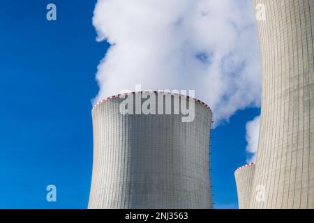 Gros plan de la centrale électrique des tours de refroidissement avec des nuages blancs de vapeur sur fond bleu ciel. Cheminées de grande taille dans une centrale nucléaire. Crise énergétique. Banque D'Images