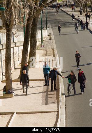 Spring Street scène de personnes jouant à la pétanque, jogging, Marche à pied, exercice, Cyclisme sur les rives de la Seine depuis le Pont Louis Phillippe, P Banque D'Images