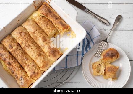 Petits pains à crêpes fourrés avec garniture de citron blanc dans un plat à pâtisserie sur fond blanc. pose à plat Banque D'Images