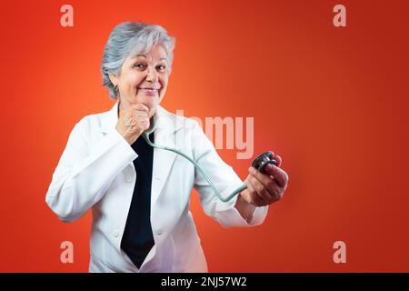 Mature brésilienne médecin ou vétérinaire femme avec stéthoscope isolé sur fond orange Banque D'Images